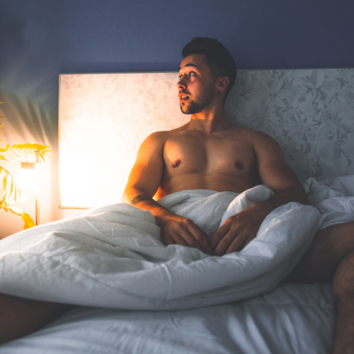 shirtless man in bed